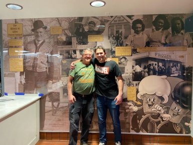 Gilles Frozen Custard Tom & Willy Linscott in front of Gilles History Wall in lobby 